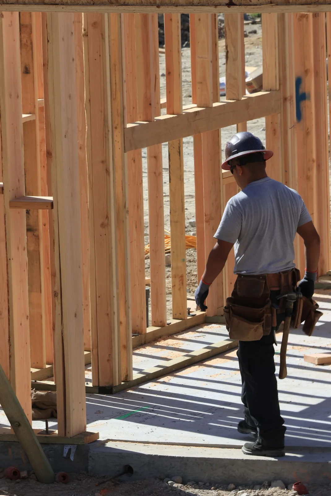 Tradesperson wearing a tool belt at a timber construction site